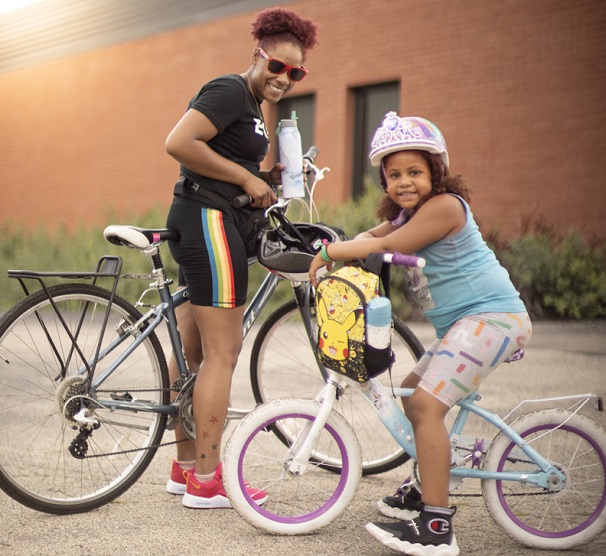 Mom and daughter on bikes smiling image