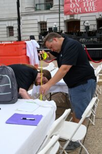 Accessibility services image of people evaluating event table height